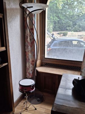 une petite pièce avec une table, une chaise et une lampe