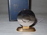 a silver plate on a gold stand next to a blue book