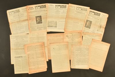 Plusieurs vieux journaux sont empilés les uns sur les autres sur une table