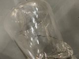 a clear glass bottle with a metal handle on a table