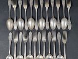 eight silverplated forks and spoons are arranged in a row
