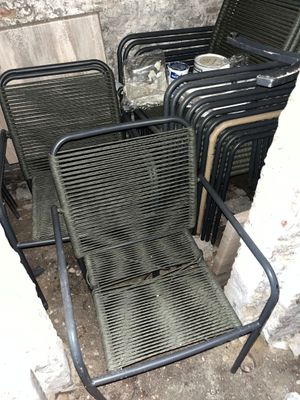 de nombreuses chaises qui sont entassées dans un coin d'un bâtiment