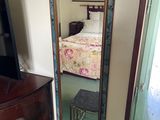 a mirror in the corner of a room with a bed in it