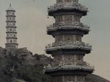 a tall tower with a clock on top of it in the middle of a mountain
