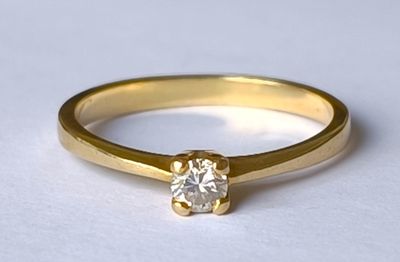 bague de fiançailles en or jaune sertie d'un diamant rond taille brillant
