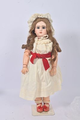 a doll that is wearing a white dress and red shoes