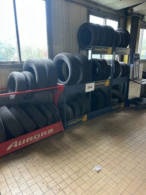 Les pneus sont empilés sur un rayonnage dans un garage doté de nombreuses fenêtres.