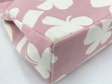 a pink purse with white flowers on it on a table