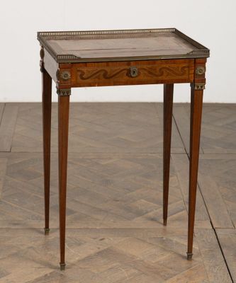 an antique wooden table with a tray on top of it on a wooden floor