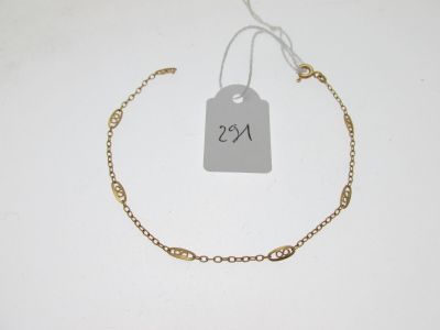 gros plan d'un bracelet en or portant une étiquette de prix
