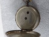 a silver pocket watch with a chain attached to it