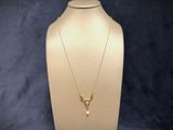 a white mannequin with a gold necklace on it