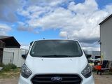 the front of a white ford transit van parked in a parking lot