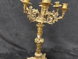 an antique brass candelabra with five candles on a stand