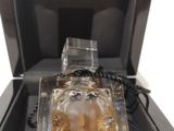 perfume bottle in a black box with a chain around it