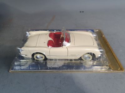 a white toy car with a red top in a clear box