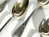 several silver spoons and spoon spoons are lined up on a white surface