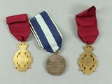 two medals and a medal on a white surface