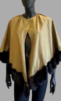 the mannequin is wearing a yellow cape with black furs