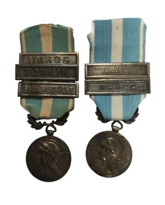deux médailles sont représentées sur un fond blanc, accompagnées d'un ruban bleu et blanc