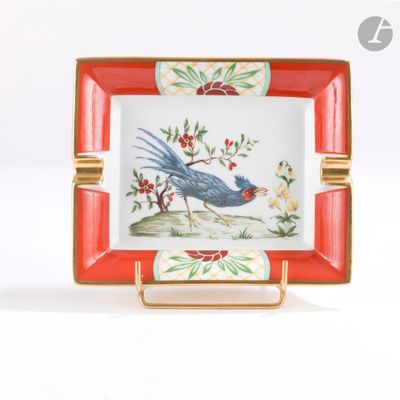 une assiette rouge et blanche sur laquelle est représenté un oiseau bleu