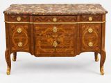 une commode ancienne avec un dessus en marbre et des poignées en laiton