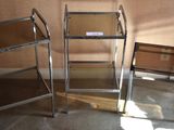 three glass shelves in the corner of a room next to a chair