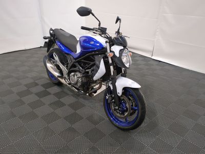 une moto bleue et blanche garée sur un sol à carreaux noirs et blancs
