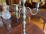 a silver candelab sitting on a table in the middle of a room