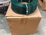 a box with a green hose on it in a warehouse