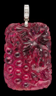 pendentif en verre rose avec un fermoir en argent sur fond noir