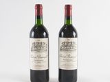deux bouteilles de vin rouge posées l'une à côté de l'autre sur une surface blanche