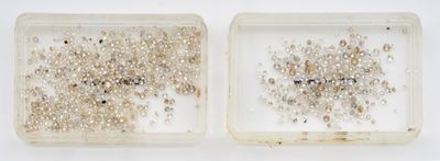 deux boîtes transparentes remplies d'une multitude de petites perles, posées sur une surface blanche