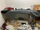 a messy room with a bed and a table in it