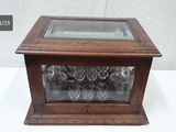 a glass case with wine glasses in it on a table