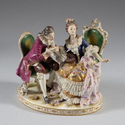 figurine représentant une famille assise sur une chaise avec un chien