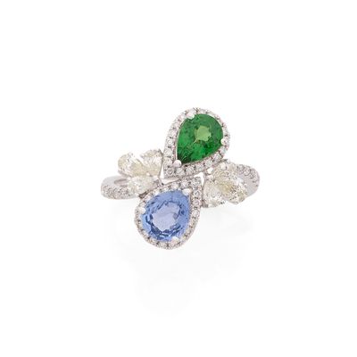 un gros plan d'une bague ornée d'une pierre verte, bleue et blanche