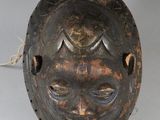 un gros plan d'un masque en bois entouré d'une corde