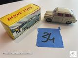 une petite voiture miniature posée sur une table, à côté d'un tissu bleu
