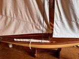 a small sailboat that is sitting on a wooden stand