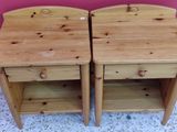 pair of wooden bedside tables with drawers on top of them