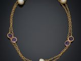 un collier en or orné de perles et d'améthystes sur fond noir