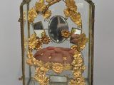 a small glass clock with a gold decoration on it