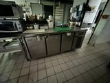 une cuisine avec beaucoup de plan de travail et un micro-ondes