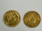 two gold coins are sitting next to each other on a white surface