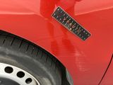 a sticker on the side of a red car with a ruler on it