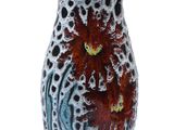 a vase with a red flower in it on a white surface