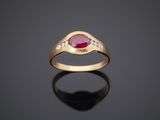 a gold ring with a ruby stone and diamonds