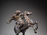 statue en bronze représentant un homme à cheval, posée sur un socle en marbre