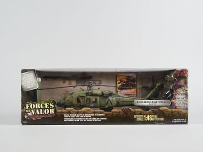 un hélicoptère militaire miniature dans une boîte, posé sur une surface blanche